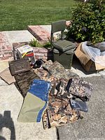 Overview of the lot outside on concrete showing clothing, seat, metal box, and boxed light