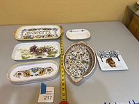 Overview of all six ceramic platters displayed on a table with a measuring tape for scale.