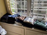 Pile of folded men's sweaters and shirts in assorted colors under natural light