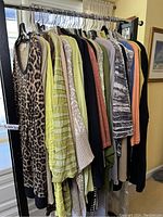 Photo showing a rack of 13 sweaters in various colors, patterns, and styles including leopard print, solids, and stripes.