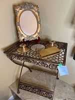 Overall photo of the metal decorative table holding the mirror, candlesticks, and jewelry box.