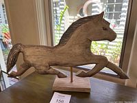 Front and side view of wooden horse sculpture showing mid-gallop pose and carved details.