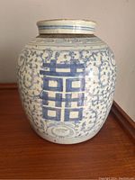 Front view of the ceramic jar showing the double happiness symbol and blue floral patterns.