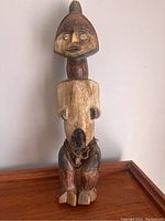 Full front view of the carved wooden African figure on a white background