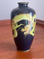 Full view of the cloisonné vase showcasing the dragon design on dark navy blue background.