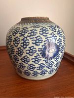 Full side view of the ovoid Chinese porcelain vase showing repeating blue motifs and floral design