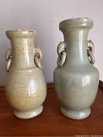 Front view of both vases side by side on wooden surface