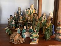 Front view of multiple mudmen figurines arranged in rows showing various poses and attire.