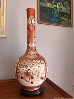 Full view of the 24-inch tall Satsuma vase seated on a wooden base, showing overall shape, colors, and hand-painted scene.