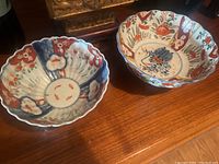 Two Japanese Amari bowls placed side by side on a wooden surface showing overall sizes and designs