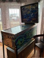 Full side view of Bally Fathom pinball cabinet showing side artwork and playfield glass