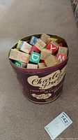 Top-down view of the Charles Chip metal can filled with colorful wooden alphabet blocks showing clear letters and design on can.