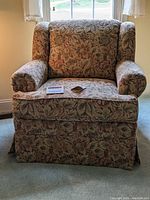 Front-facing view of the plush floral patterned armchair under natural light.