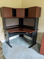 Corner wood-look desk with attached hutch and keyboard tray, shown from front view