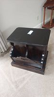 Full view of dark wooden end table with 2-door book rack design, showing top and front sides.