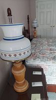 Photo of one lamp showing wooden base and floral pattern on glass shade