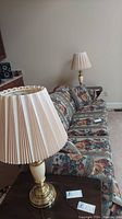 Two Stiffel table lamps on side table next to floral-patterned sofa, showing general size and style.