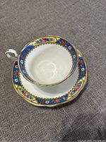 Top down photo of the Aynsley teacup nested inside the saucer showing floral and gold trim design