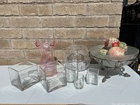 Wide shot showing all items in the lot including the decorative balls in the silver bowl and the variety of glass vases.