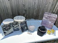Wide view of lot including two clear jewelry organizers, three bridal jewelry sets, heart clutch, black bust with tiara, and two yellow glass perfume bottles