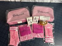 Lot overview displaying all items including cosmetic cases, socks, drink koozies, tissues, and accessories.