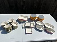 Top view of all ovenware ramekins and soup bowls arranged on white table outdoors.