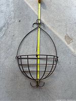 Front view of metal plant basket with measuring tape showing height about 32 inches and hook on top for hanging.
