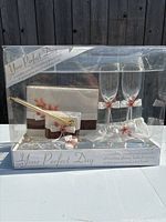 Front view of boxed wedding set including toasting glasses, guestbook, pen, and other accessories.