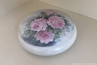 Top view of the closed powder jar showing the hand-painted pink cabbage roses design on the lid.