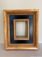 Full front view of the antique style gilt wood frame showing the black and gold finish.