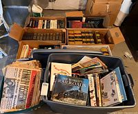 Multiple bins filled with vintage newspapers mostly about the Kennedy assassination and various used books.