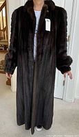 Front view of full-length dark brown mink coat worn by model