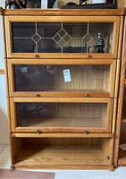 Front view of entire bookcase showing three glass-front sections and open base