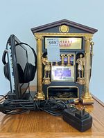 Photo showing Sony TV, headphones and the Caesars Palace jackpot toy game machine on a table.
