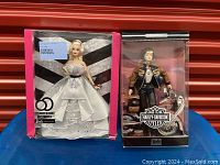 Photo of both Barbie dolls in original boxes: 2019 60th Anniversary Barbie in white and silver dress, and 1999 Harley-Davidson Barbie with motorcycle.