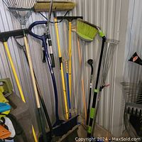 Full view of garden and cleaning tools lined up against wall