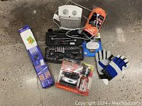 Full lot overview showing heater, socket set, inflator kit, work gloves, drill bits, and extension cord on concrete floor