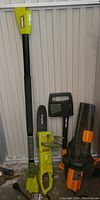 Photo of Sunjoe extension handle, Sunjoe chainsaw and Worx leaf blower stacked together.