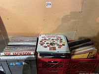 Three milk crates filled with vinyl records, showing album covers such as Joe Jackson, Lou Reed, and The Lollipop Tree