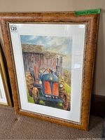 Full view of the framed watercolor painting showing a blue and orange tractor and rustic barn on textured carpeted floor.