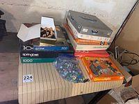 Overview of all puzzles, chess pieces box, bag of marbles and Disney Spin game on a table.