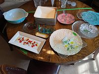 Overview of all platters and bowls including Pyrex mixing bowl, glass and ceramic plates and platters on wooden table