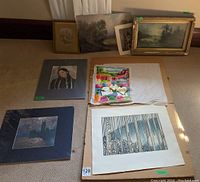 Full lot of art prints and paintings including framed and unframed pieces laid out on the floor.