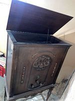 Closed wooden radio cabinet with top lid opened, showing empty interior space