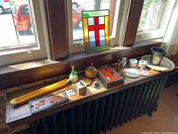 Wide view of all items on windowsill including stained glass panel, trays, dishes, coasters, containers, and small cups