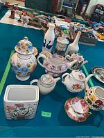 Overview of all teapots, jars, cups and saucers arranged on table