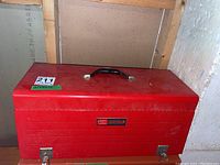 Closed red metal Sears Craftsman toolbox showing branding and general condition