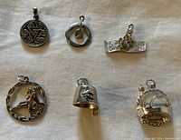Top view of six sterling silver charms showing all distinct designs.