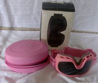 Pink JiDue eye massager displayed with its pink protective hard case and original retail box featuring product image.