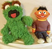 Oscar the Grouch and Ernie sitting side by side on a plain background, showing their front view and overall condition.